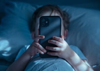 Age verification laws aren't a substitute for parenting. A stock photo of a child staring at his phone.