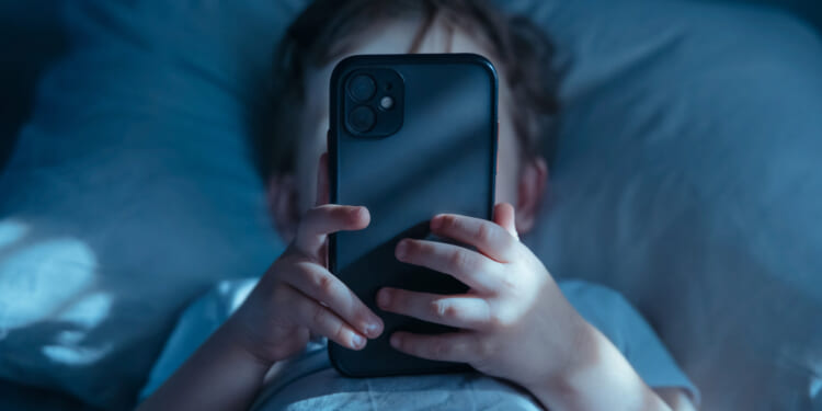 Age verification laws aren't a substitute for parenting. A stock photo of a child staring at his phone.