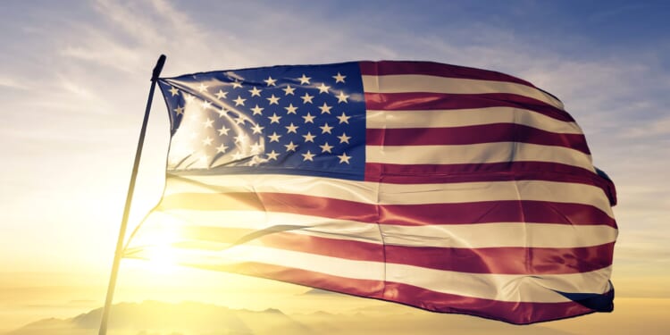 United States american usa us flag textile cloth fabric waving on the top sunrise mist fog stock photo