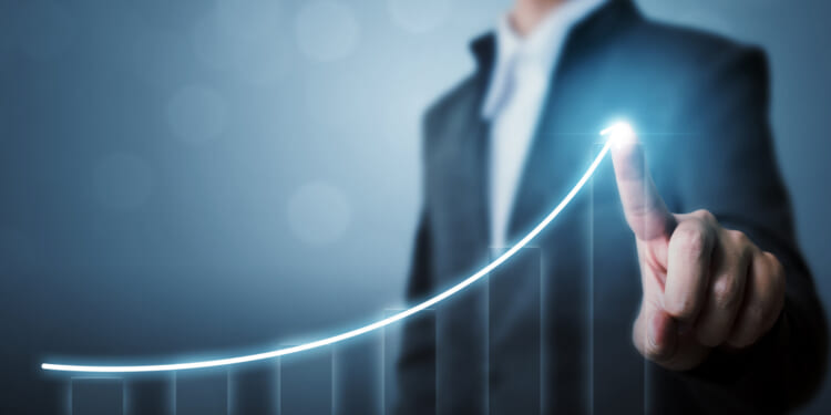 An image of a man drawing the outline of a graph increasing and going up, demonstrating the economic growth of small business.