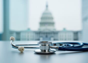A stethoscope on a table with the U.S. Capitol blurred in the background.